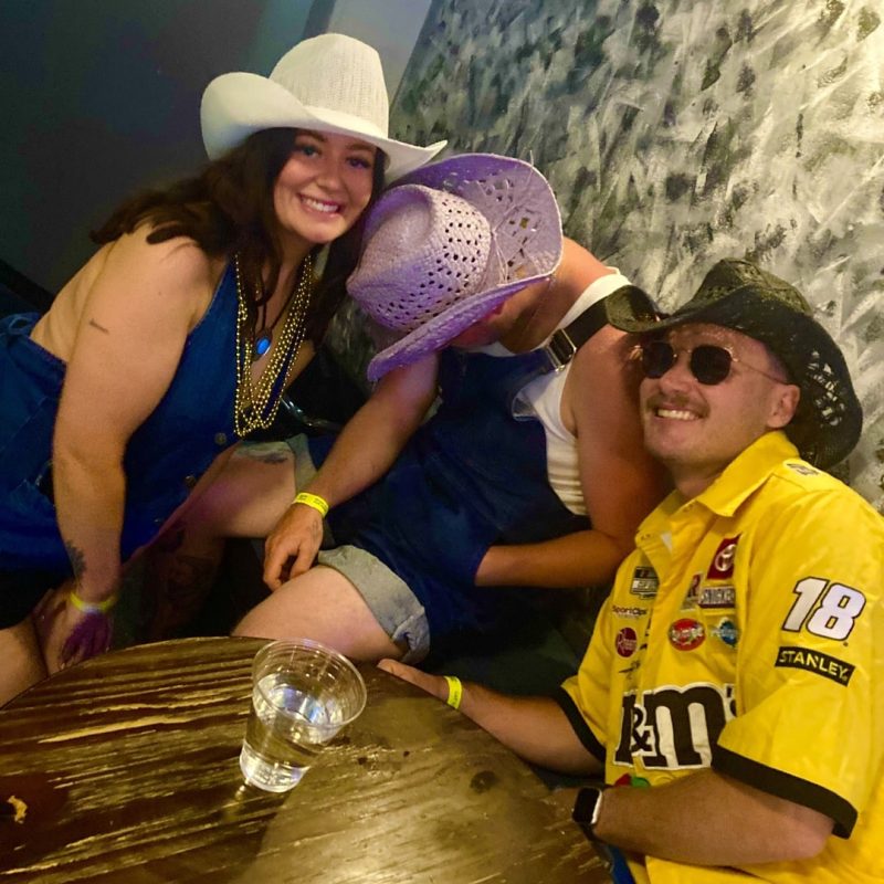 Friends Posing Next To Passed Out Bachelor