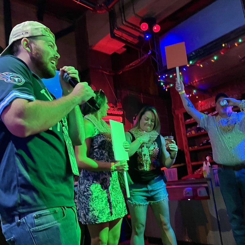 Tour Guide Presenting Game Results To Team Leaders On Stage In Nashville